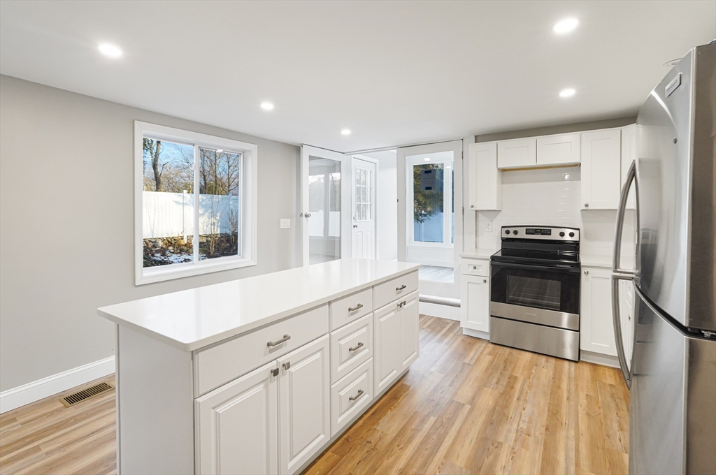 a kitchen with white cabinets and stainless steel appliances