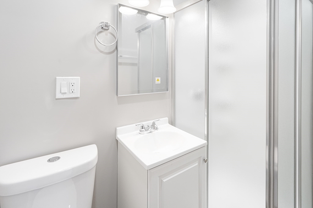 98 Southville Road, Unit B Southborough, MA 01772 - Photo 16 of 32 a bathroom with a sink a toilet and a mirror