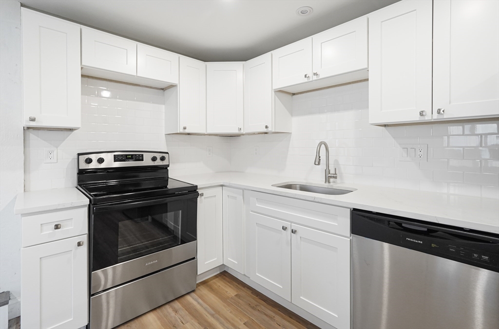 98 Southville Road, Unit B Southborough, MA 01772 - Photo 3 of 32 a kitchen with granite countertop white cabinets stainless steel appliances and sink