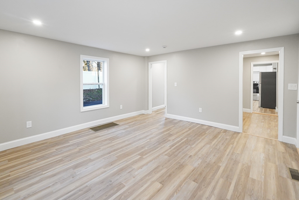 98 Southville Road, Unit B Southborough, MA 01772 - Photo 10 of 32 a view of an empty room with wooden floor and a window