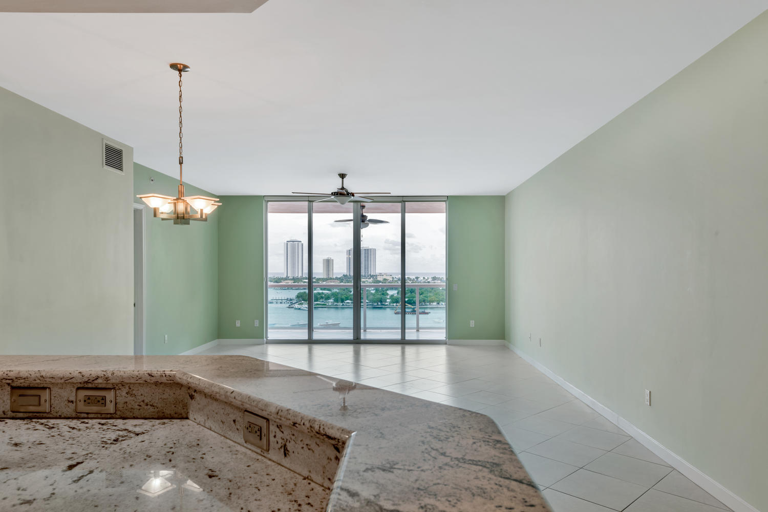 2640 Lake Shore Drive, Unit 1011 Riviera Beach, FL 33404 - Photo 11 of 60 a living room with a bed furniture and a chandelier