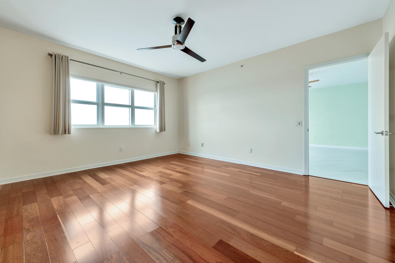 2640 Lake Shore Drive, Unit 1011 Riviera Beach, FL 33404 - Photo 13 of 60 a view of empty room with wooden floor and fan