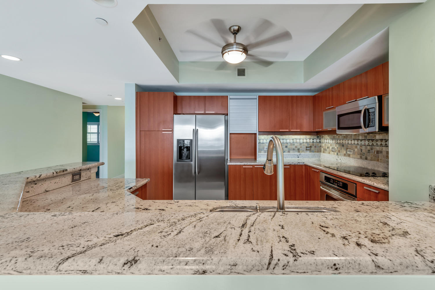 2640 Lake Shore Drive, Unit 1011 Riviera Beach, FL 33404 - Photo 9 of 60 a view of kitchen island a sink stainless steel appliances and cabinets