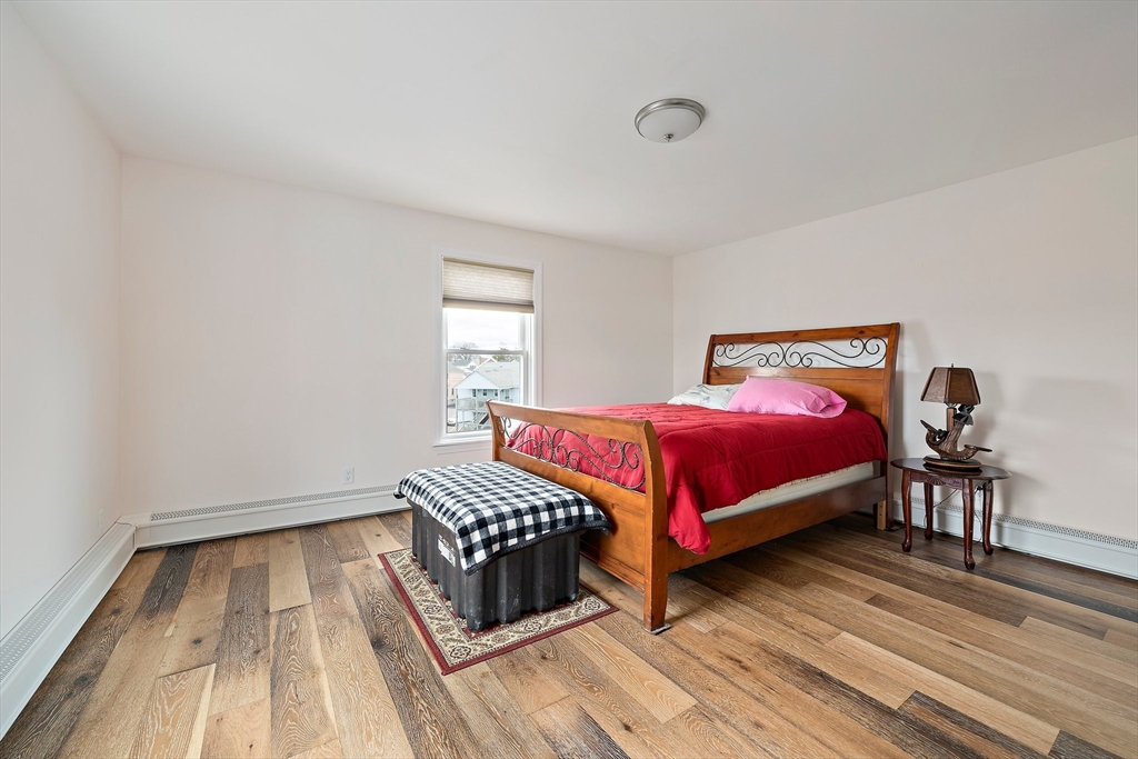 91 Shellton Road Quincy, MA 02169 - Photo 9 of 31 a bedroom with a bed and wooden floor
