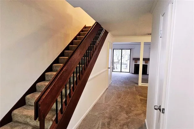 a view of staircase with lots of frames on wall and a window