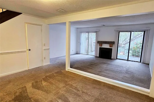a view of an empty room with a fireplace and a window