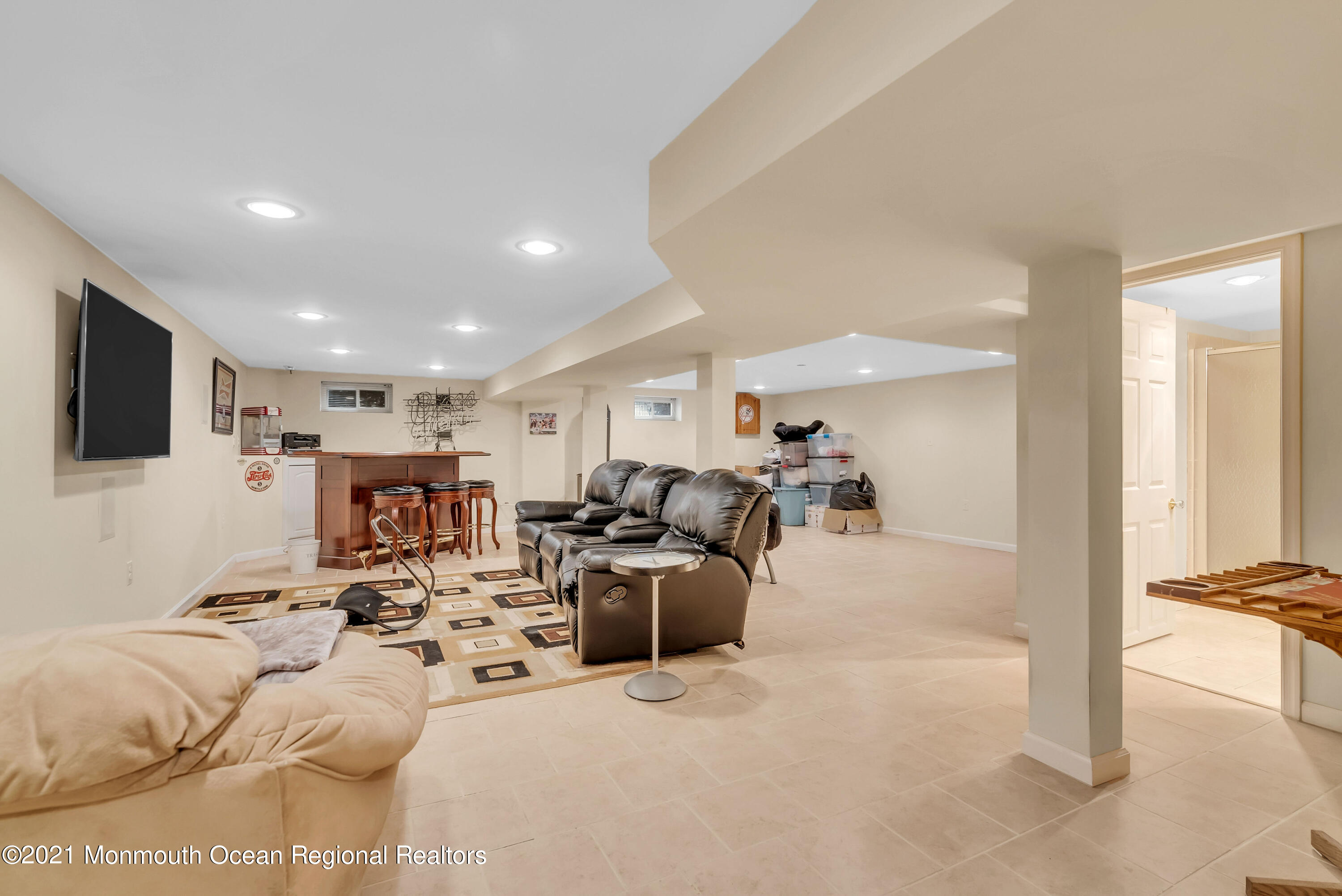 128 Whalepond Road Oakhurst, NJ 07755 - Photo 24 of 33 a living room with furniture a flat screen tv and a large window