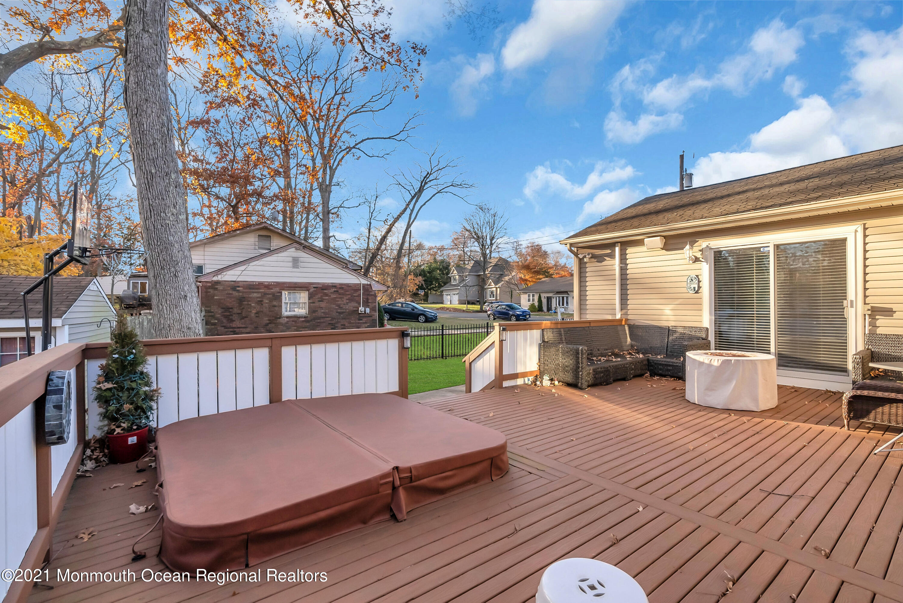 128 Whalepond Road Oakhurst, NJ 07755 - Photo 28 of 33 a view of a patio with couches table and chairs and wooden floor