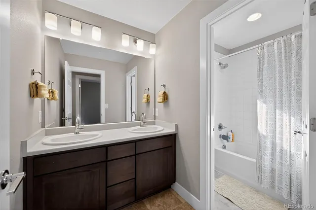 a bathroom with a double vanity sink and a mirror