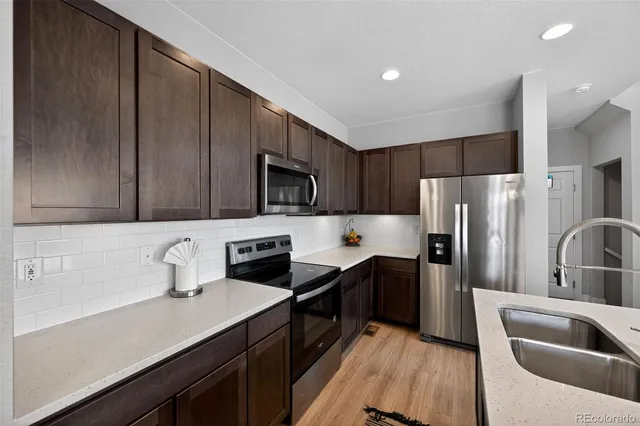 a kitchen with stainless steel appliances a refrigerator sink and microwave