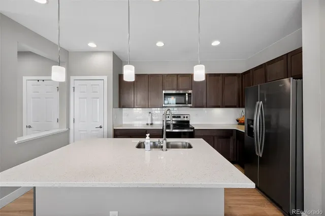 a large white kitchen with a refrigerator a stove a sink and a oven