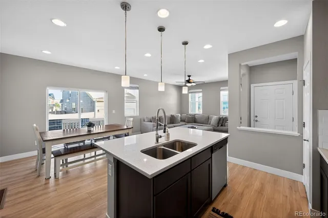 a kitchen with a sink a counter top space and living room view