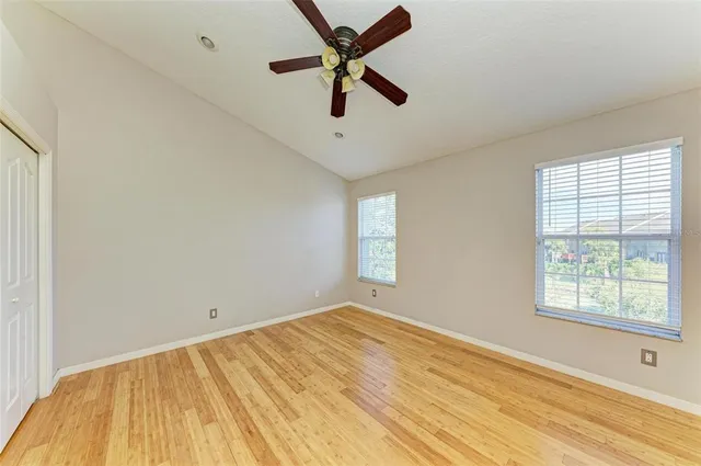 a view of empty room with window and ceiling fan