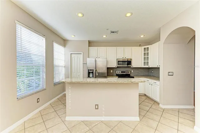 a kitchen with stainless steel appliances a refrigerator sink and cabinets