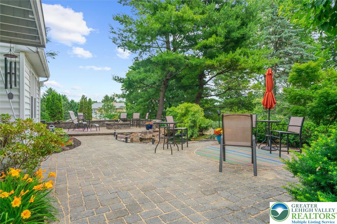 5616 Snowdrift Road Orefield, PA 18069 - Photo 32 of 36 An inviting paver patio extends into a serene garden, perfect for outdoor gatherings.