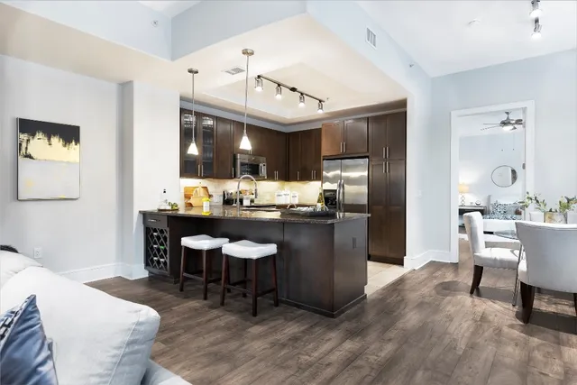 a kitchen with a dining table chairs cabinets and stainless steel appliances