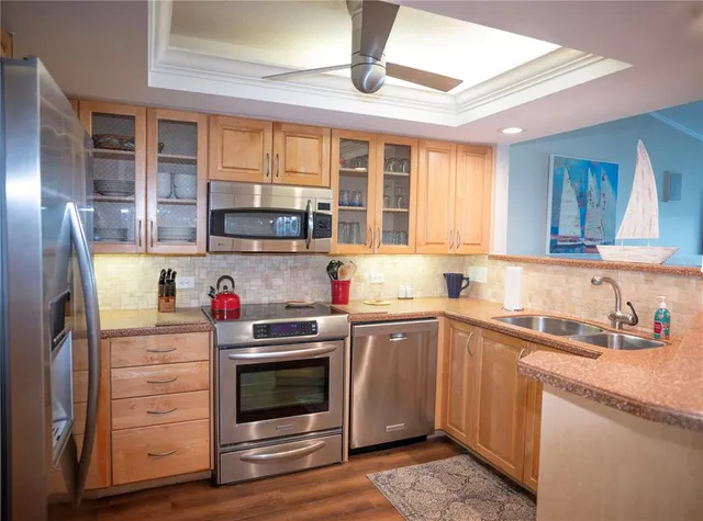 a kitchen with stainless steel appliances granite countertop a sink and a refrigerator