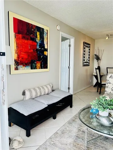 a living room with furniture and painting on the wall