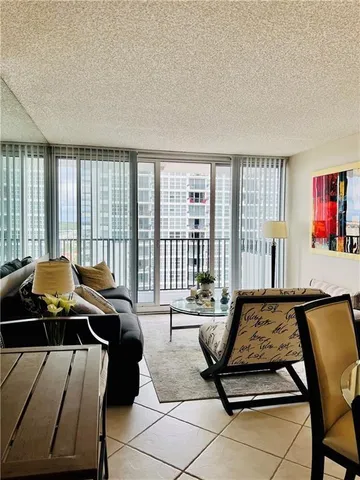 a living room with furniture floor to ceiling windows and a rug