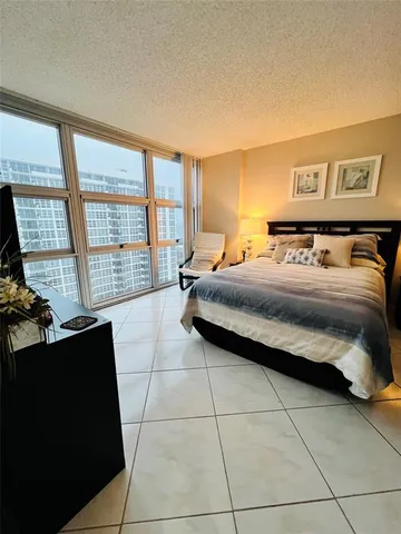 a bedroom with a bed and a dresser next to a window