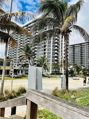 a front view of a building with palm trees