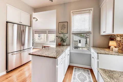 a kitchen with stainless steel appliances granite countertop a sink refrigerator and microwave
