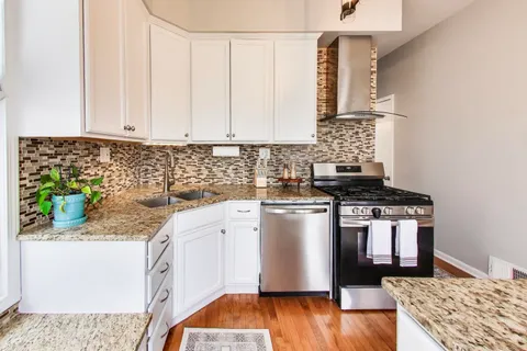 a kitchen with stainless steel appliances granite countertop a stove a sink and a microwave