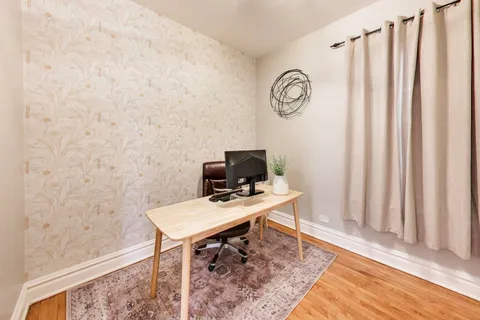 a view of a workspace with furniture and a window