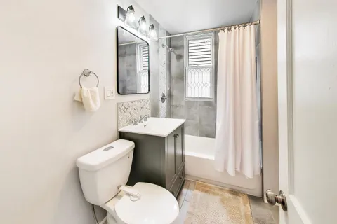 a bathroom with a toilet a sink and mirror