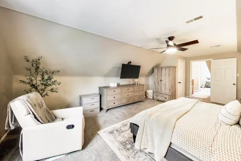 a spacious bedroom with a bed and a chair