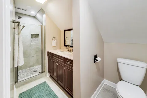 a bathroom with a granite countertop toilet a sink and a mirror