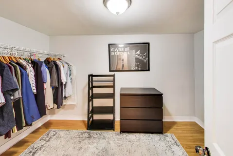 a view of walk in closet with clothes and shoes