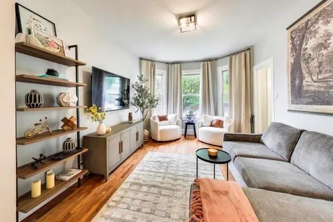 a living room with furniture a rug and a window