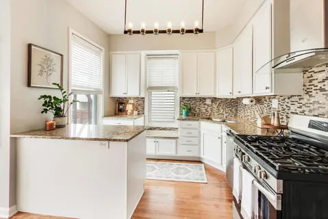 a kitchen with stainless steel appliances granite countertop a sink stove and cabinets