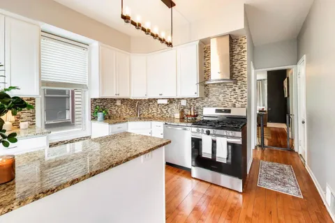 a kitchen with stainless steel appliances granite countertop a stove a sink and a microwave