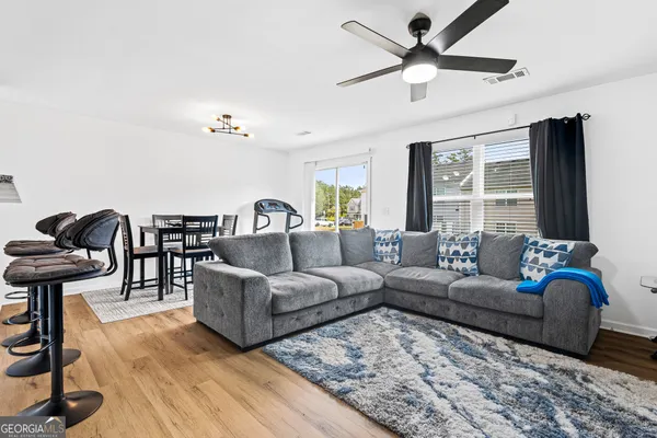 a living room with furniture ceiling fan and a rug