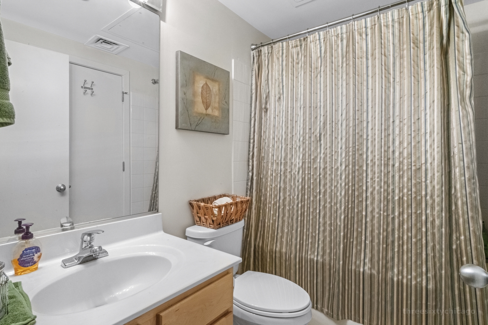 208 West Washington Street, Unit 1002 Chicago, IL 60606 - Photo 11 of 16 a bathroom with a sink a toilet and shower curtain