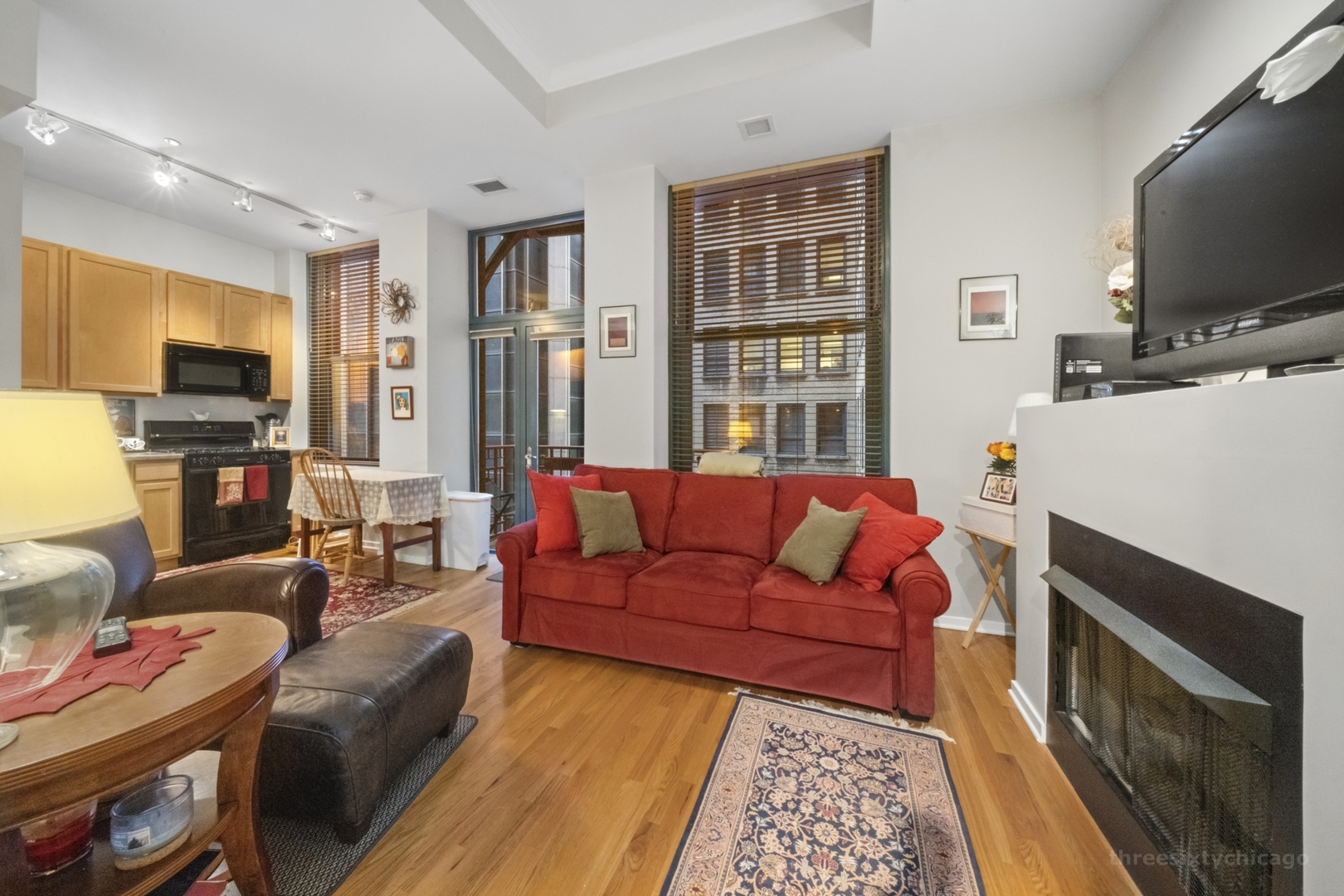 208 West Washington Street, Unit 1002 Chicago, IL 60606 - Photo 2 of 16 a living room with furniture a flat screen tv and a fireplace