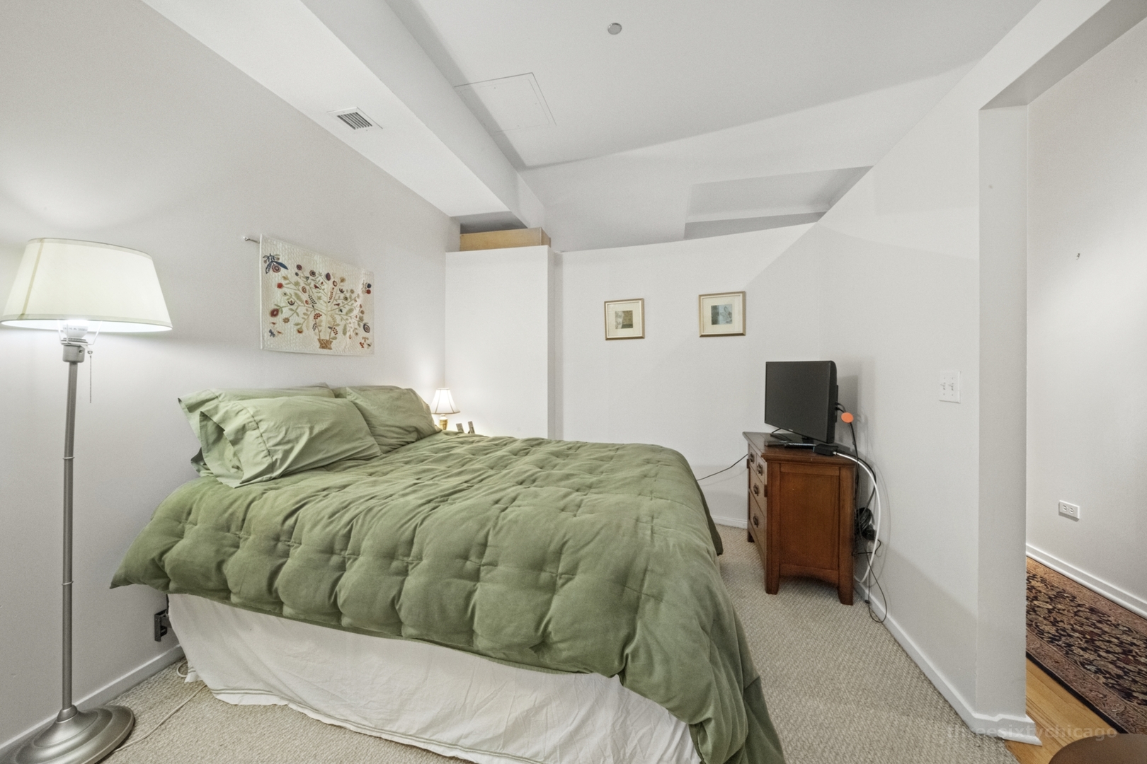 208 West Washington Street, Unit 1002 Chicago, IL 60606 - Photo 7 of 16 a bedroom with a bed and a flat screen tv