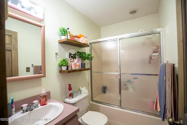 a bathroom with a sink mirror toilet and shower