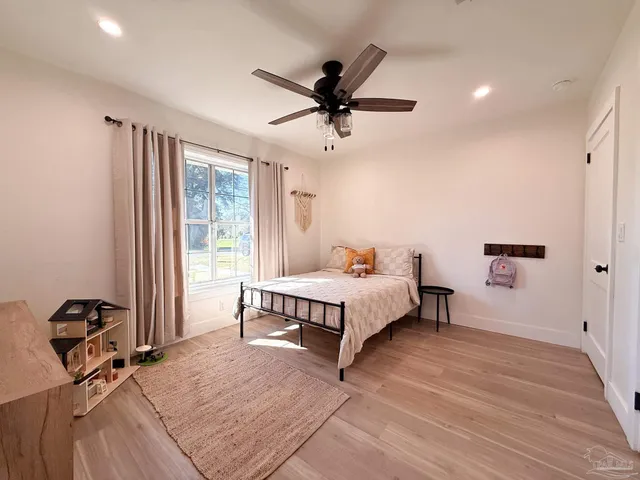 a bedroom with a bed and wooden floor