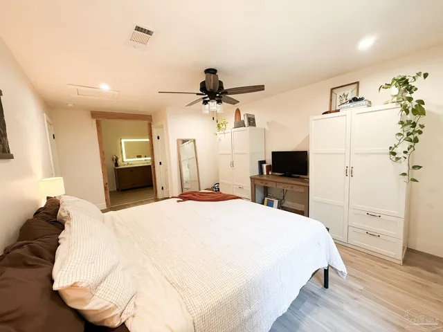 a spacious bedroom with a bed and a flat screen tv