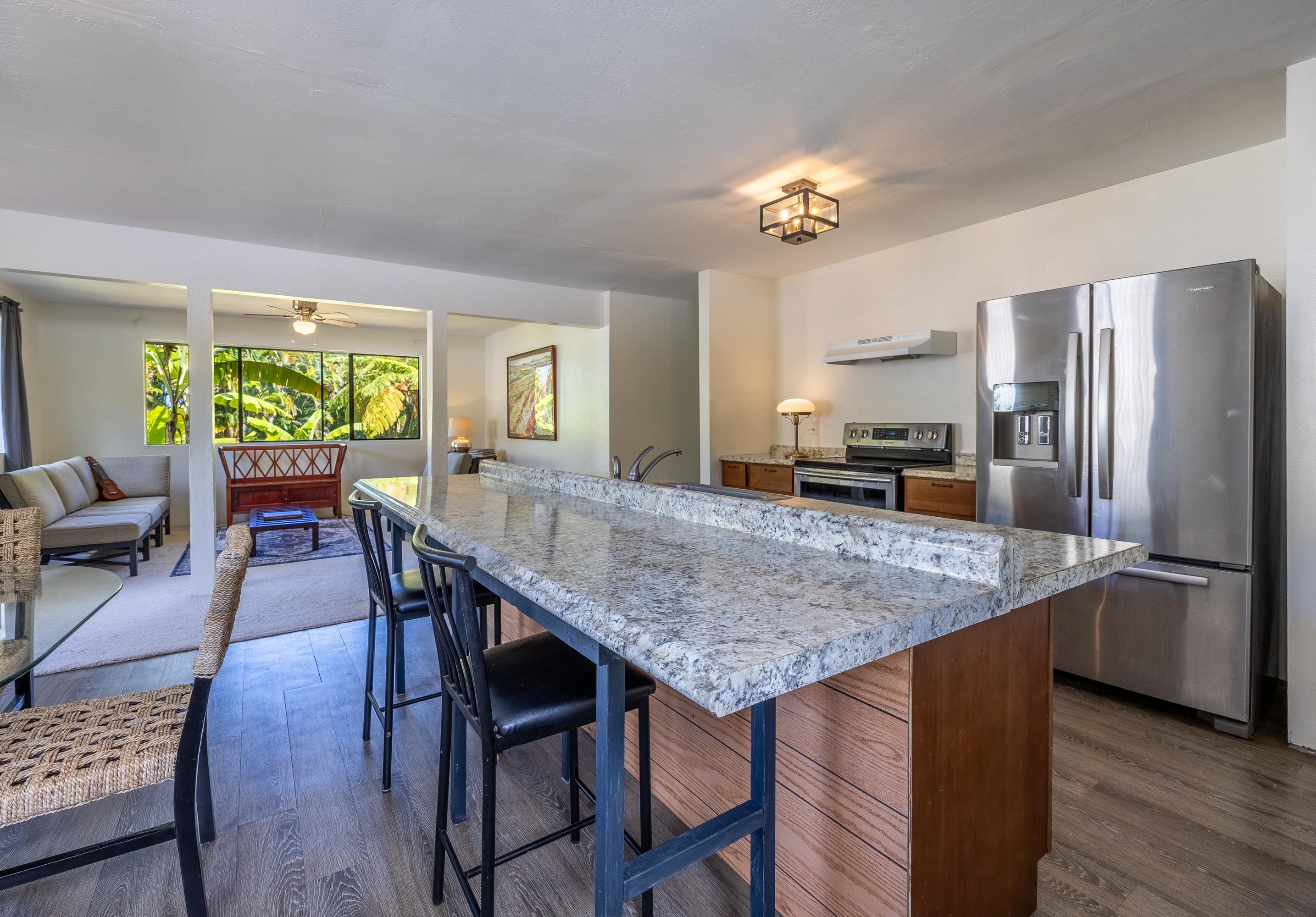 81 Kapuai Road Haiku, HI 96708 - Photo 15 of 50 a kitchen with a table chairs refrigerator and microwave