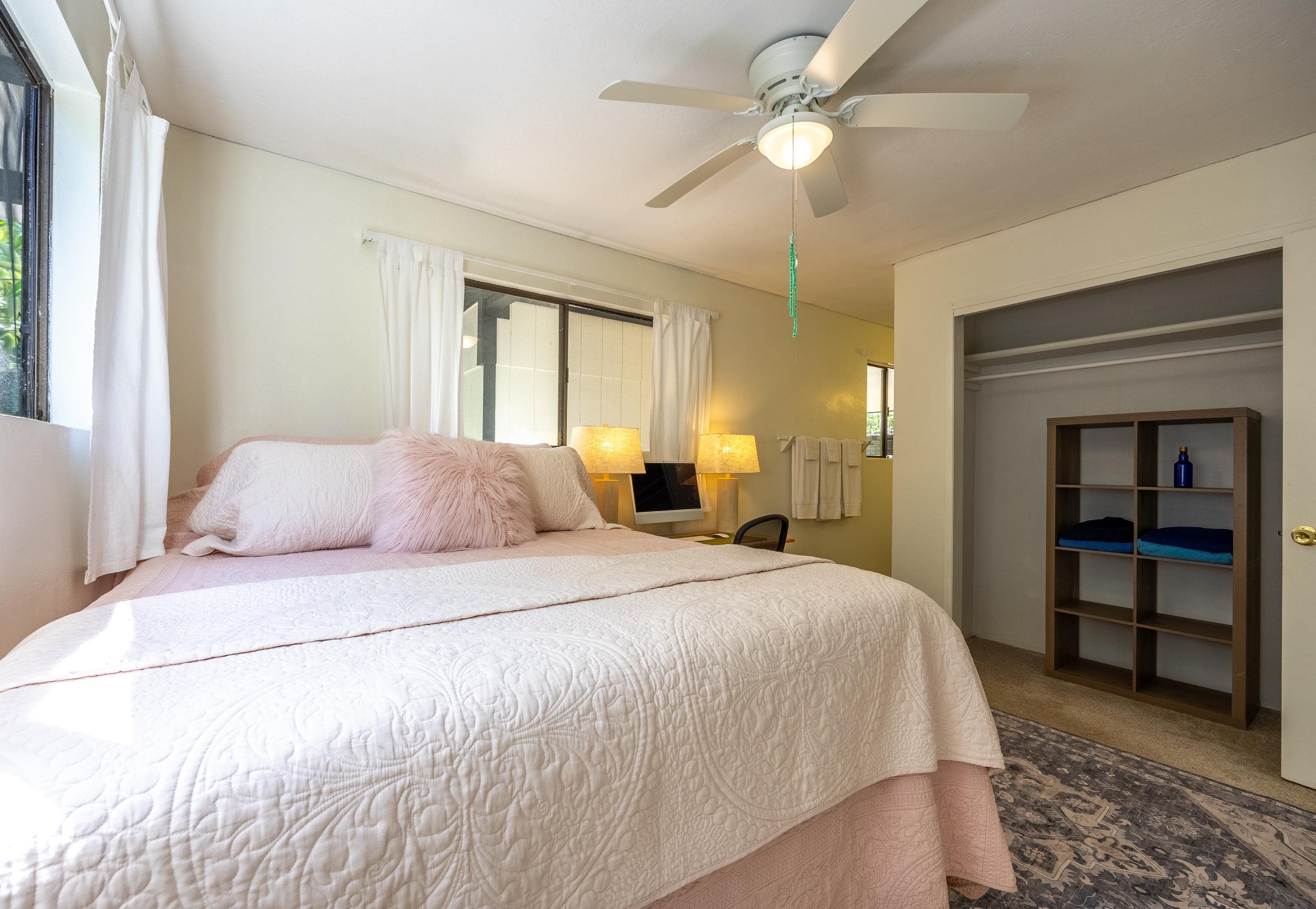 81 Kapuai Road Haiku, HI 96708 - Photo 26 of 50 a spacious bedroom with a bed and a chandelier