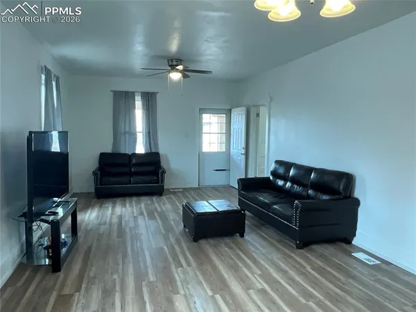 a living room with furniture and wooden floor