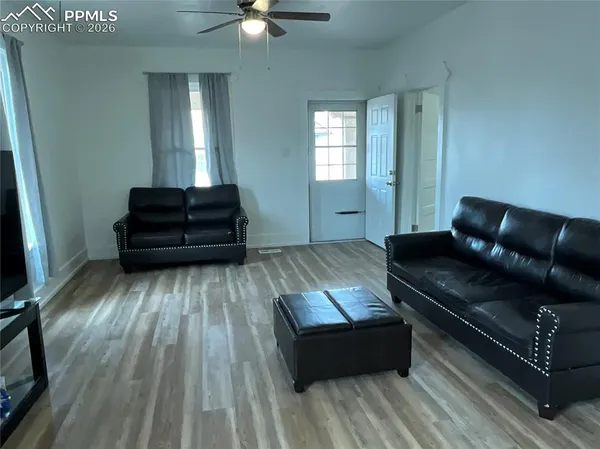 a living room with a couch wooden floor and a window