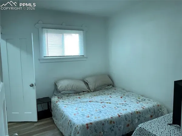 a bedroom with a bed and wooden floor