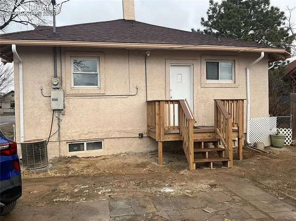 a view of a house with a patio and a yard