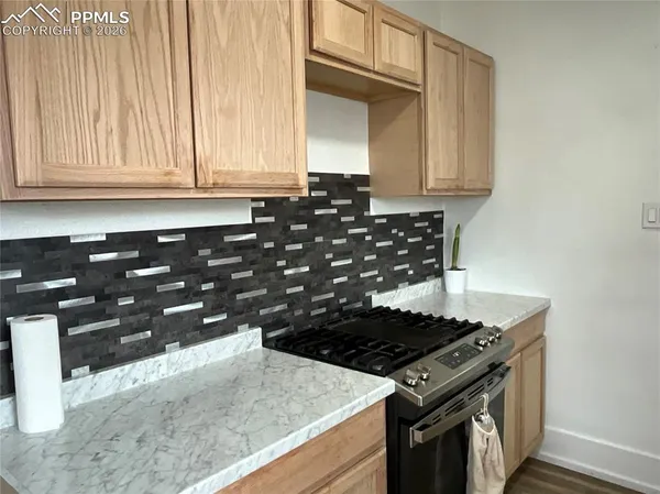 a kitchen with granite countertop a stove and a sink