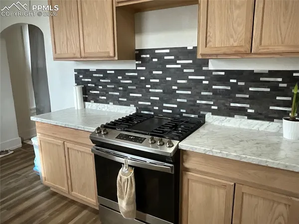 a kitchen with granite countertop a stove and cabinets